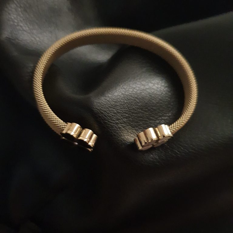 bracelet en acier inoxydable doré, avec le symbole des quatre feuilles de trèfle en noir et blanc